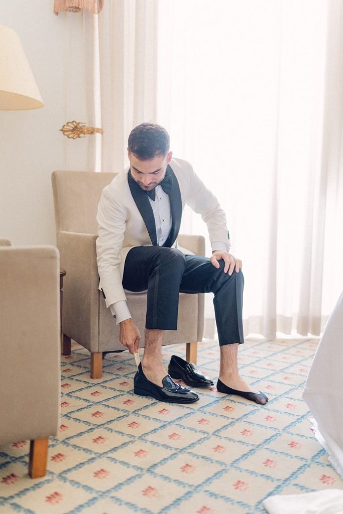 Groom adjusting shoe before ceremony at Lisbon palace wedding