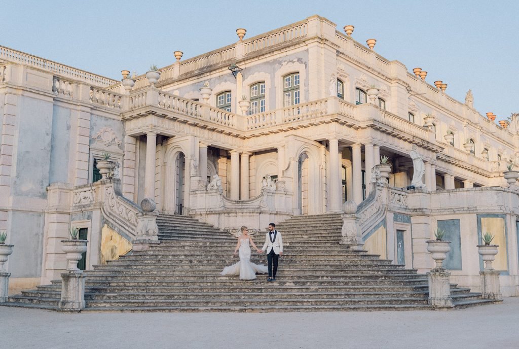 Bride and groom walking through Queluz Palace gardens