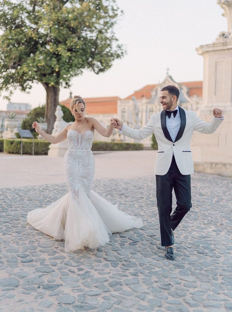 couple walking holding hands celebrating at queluz palace in Portugal