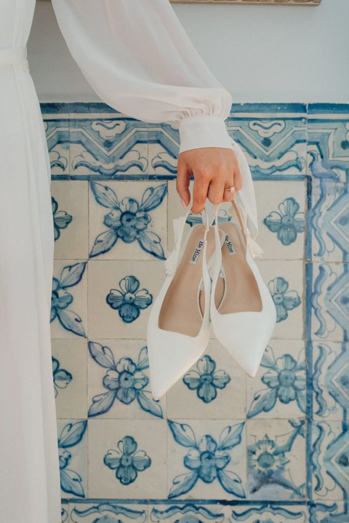 Bridal shoes and engagement ring beside Portuguese blue tiles