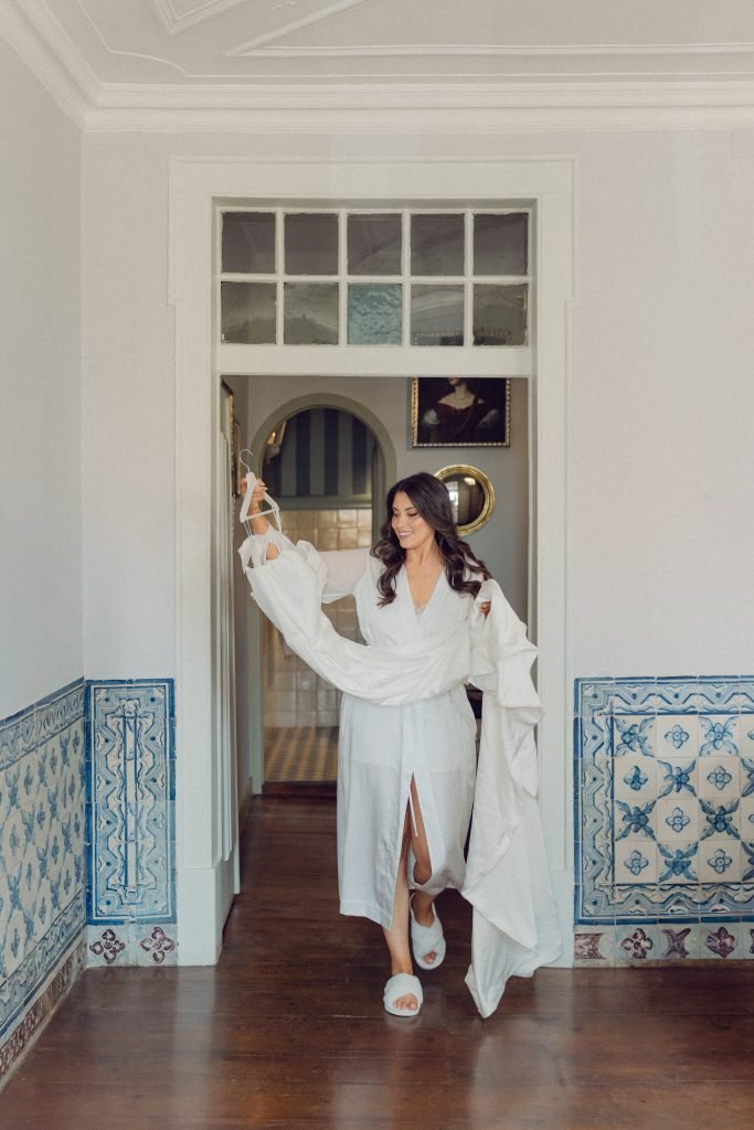 Bride holding wedding dress before ceremony in Portugal
