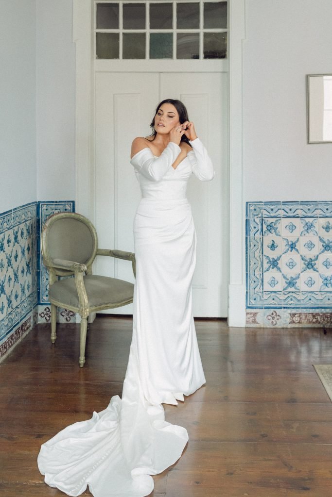 Bride fastening earrings before Lisbon wedding ceremony