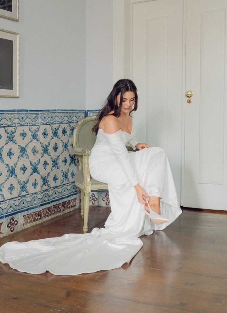 Bride putting on wedding shoes before Vandelli Botanical Garden ceremony