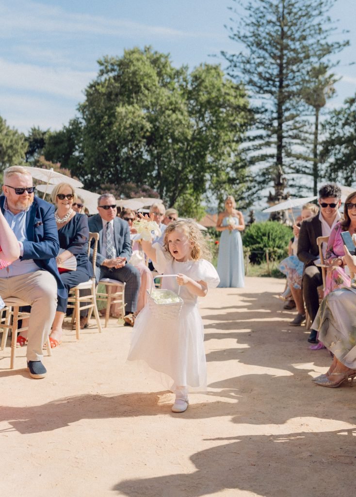 Flower girl walking down the aisle at Lisbon garden wedding