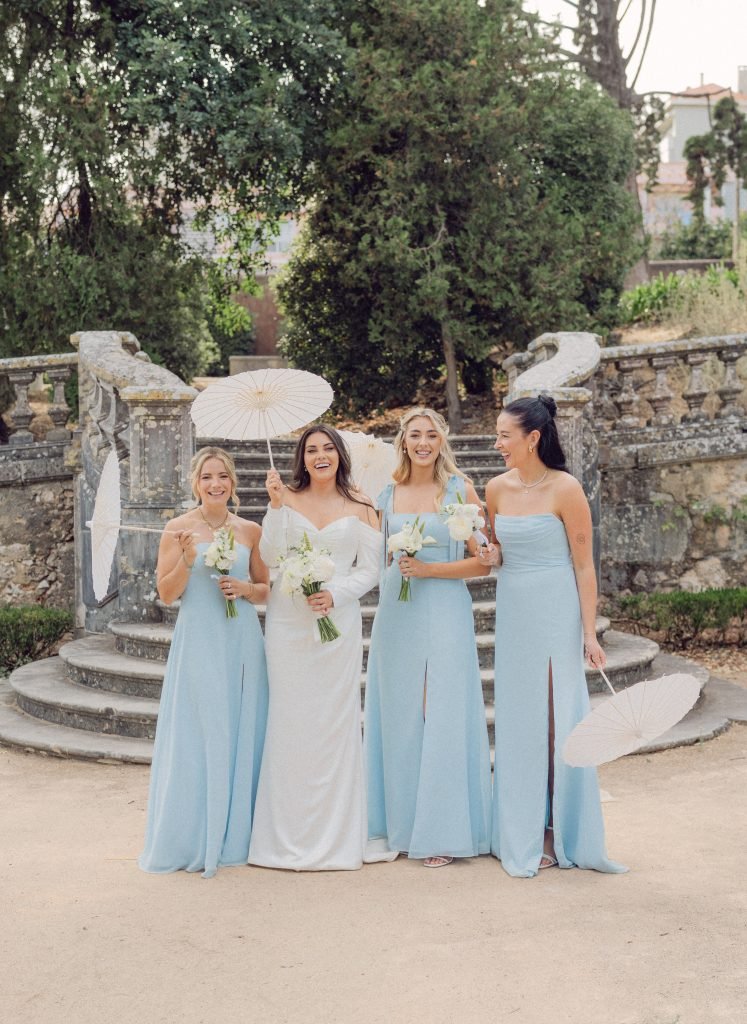 Bride with bridesmaids holding parasols before Lisbon wedding